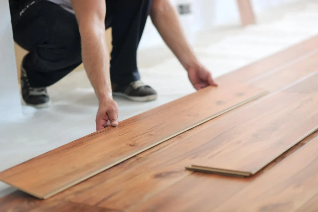 Professional Worker installing luxury vinyl planks on a new floor.
